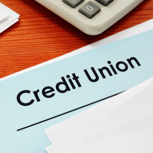 A blue paper that says "Credit Union" on a desk with a calculator