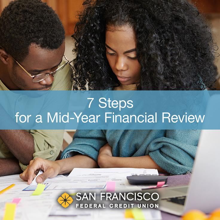 A man and woman looking at paperwork on a table with a laptop, and text displayed: 7 Steps for a Mid-Year Financial Review
