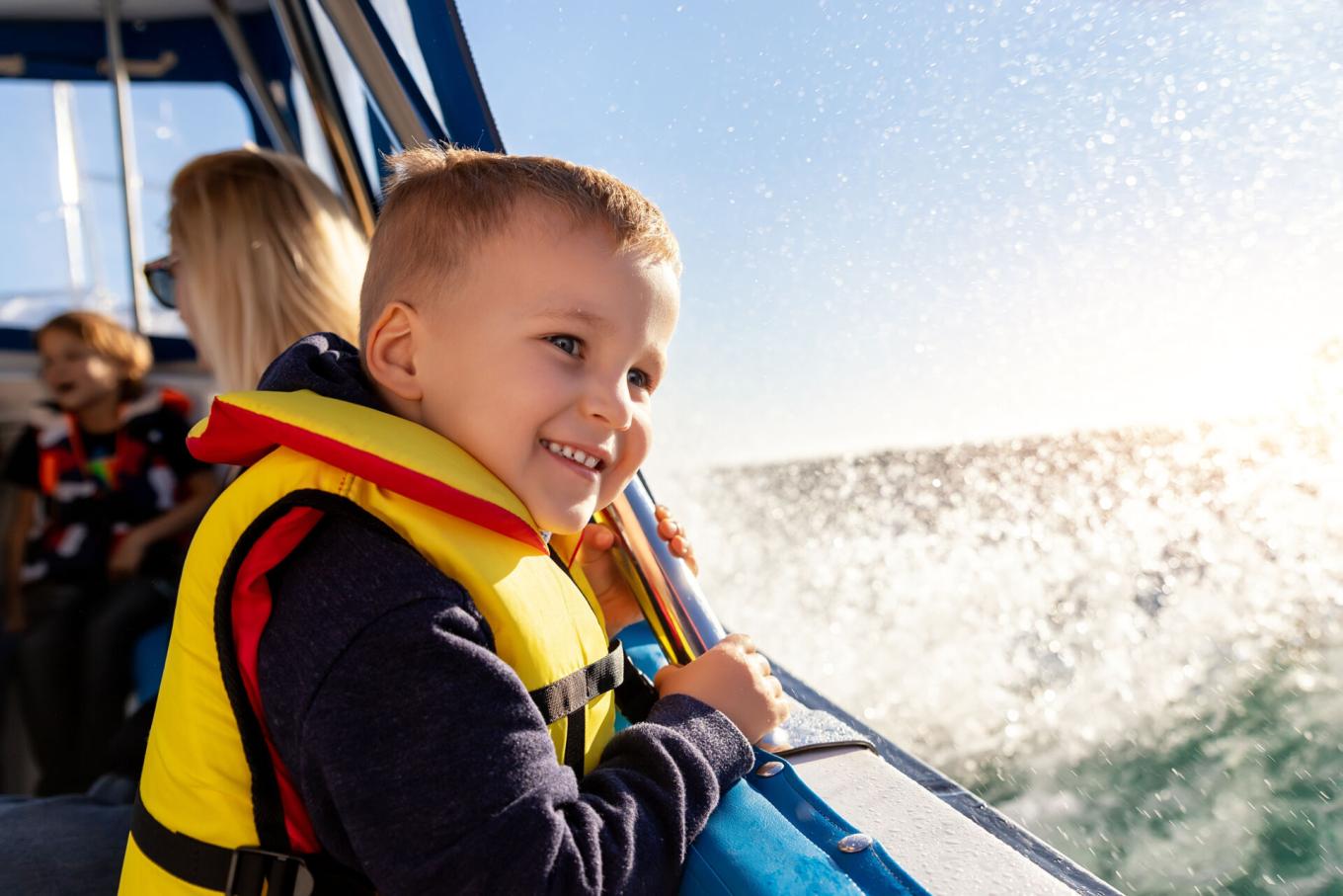 A child in a boat wearing a lifejacket